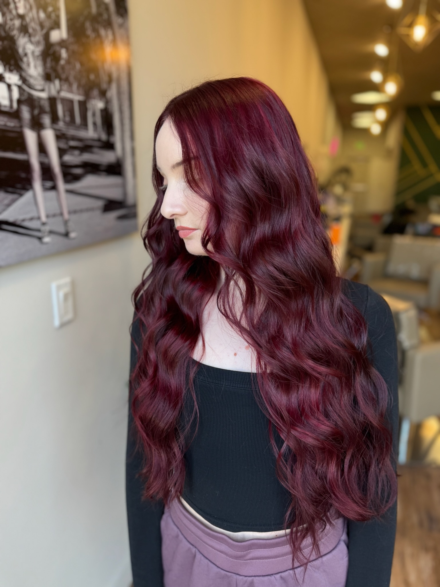 Vibrant cherry cola red hair with a touch of violet, styled with effortless waves by Jewell Crandell at Vamp Salon.